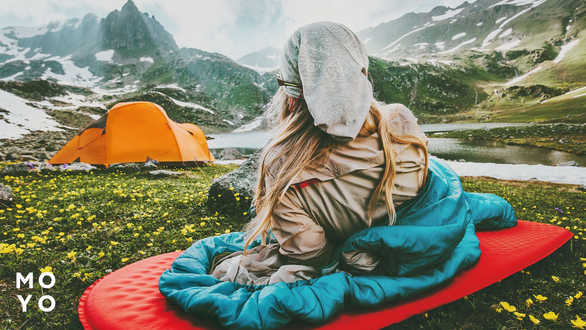 Девушка в горах на надувном коврике