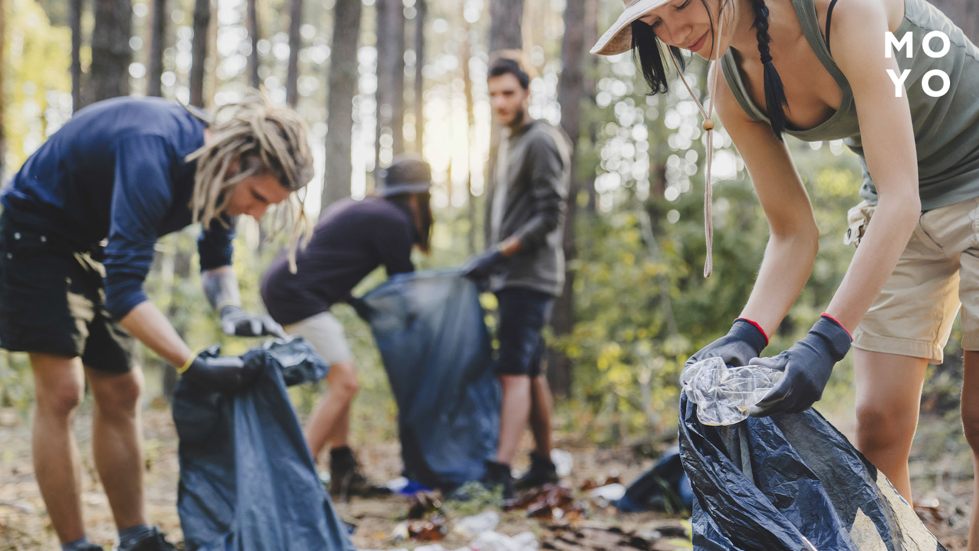 Компанія друзів прибирають за собою після пікніка