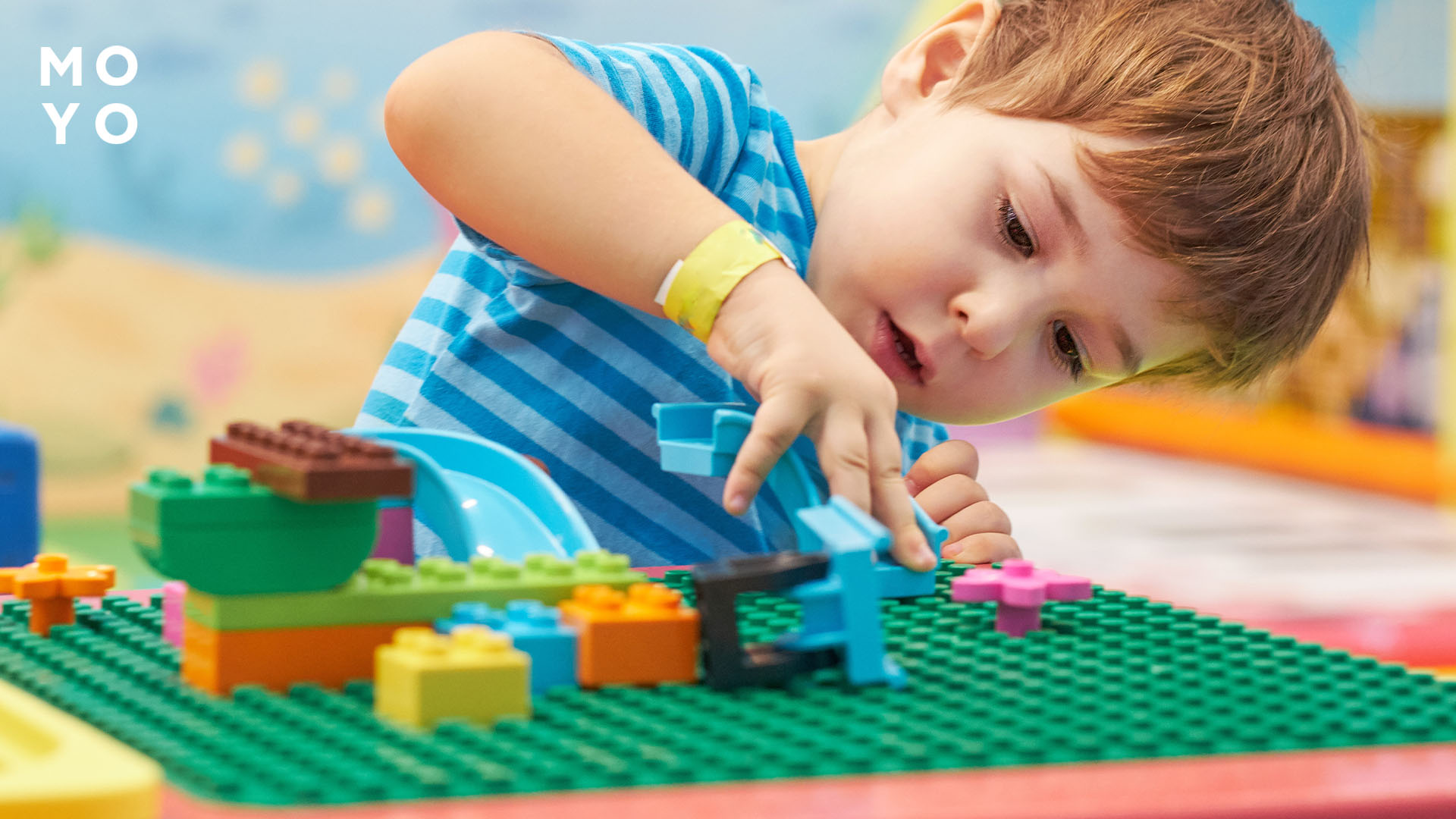 дошкільник конструює з LEGO