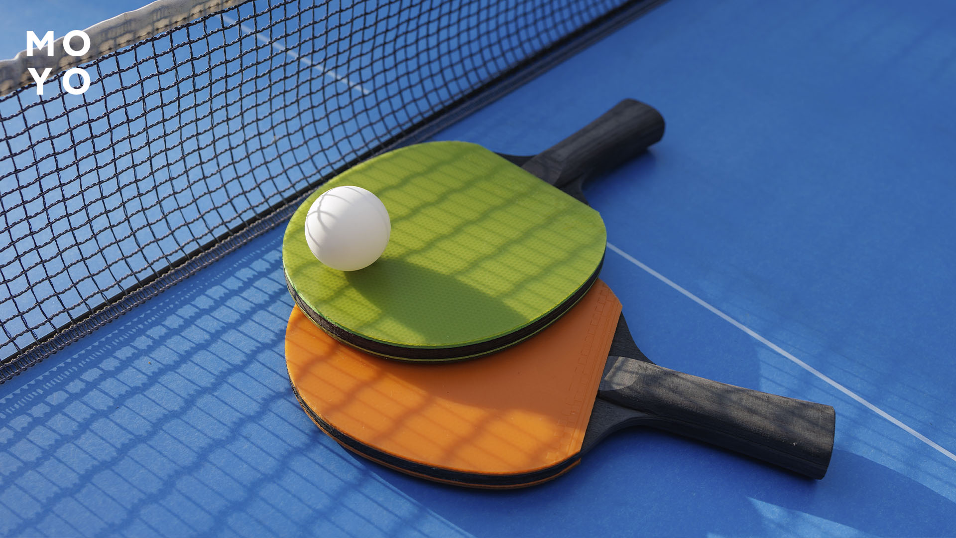 Тенісні ракетки на столі з м'ячем