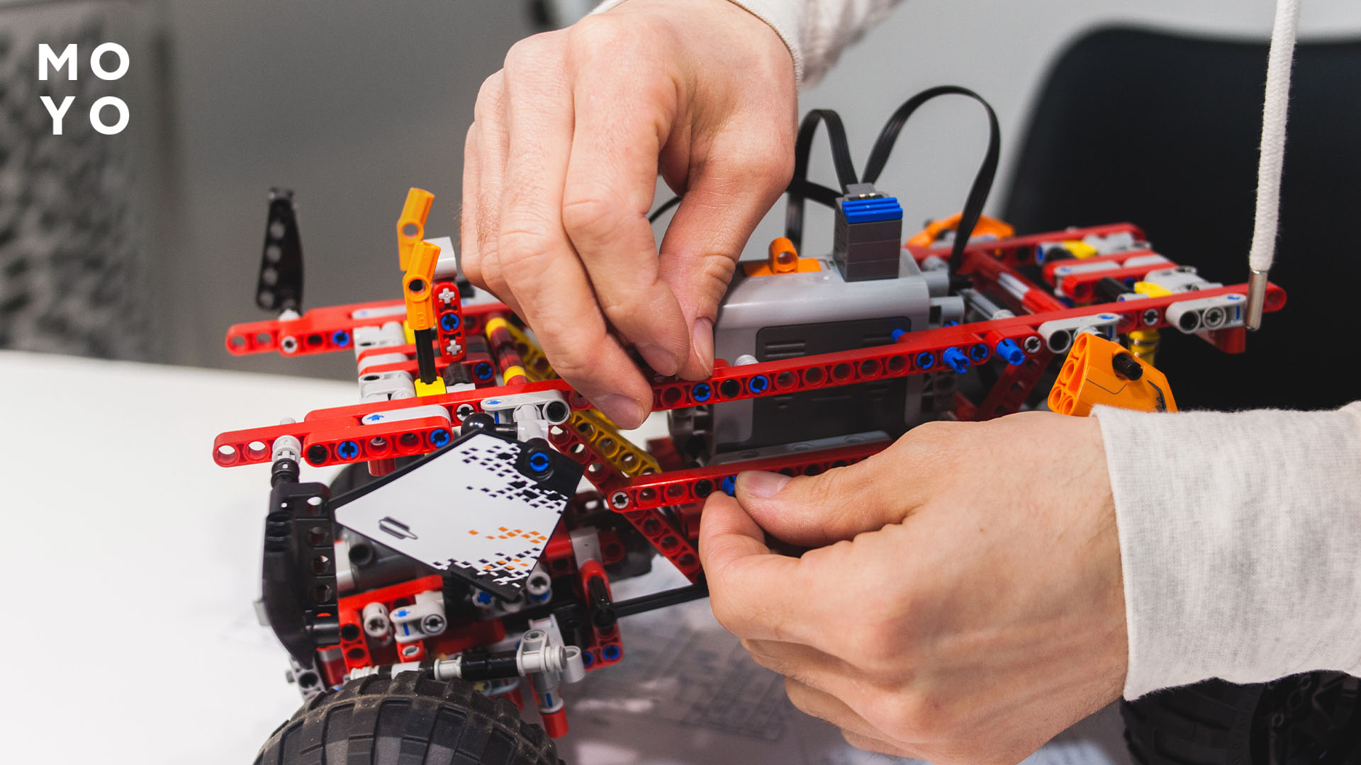 дорослий збирає машину LEGO на радіокеруванні