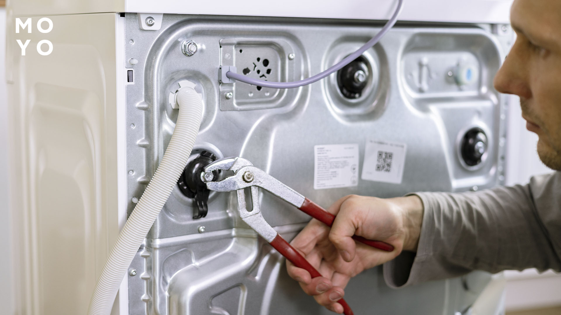 майстер ремонтує пральну машину