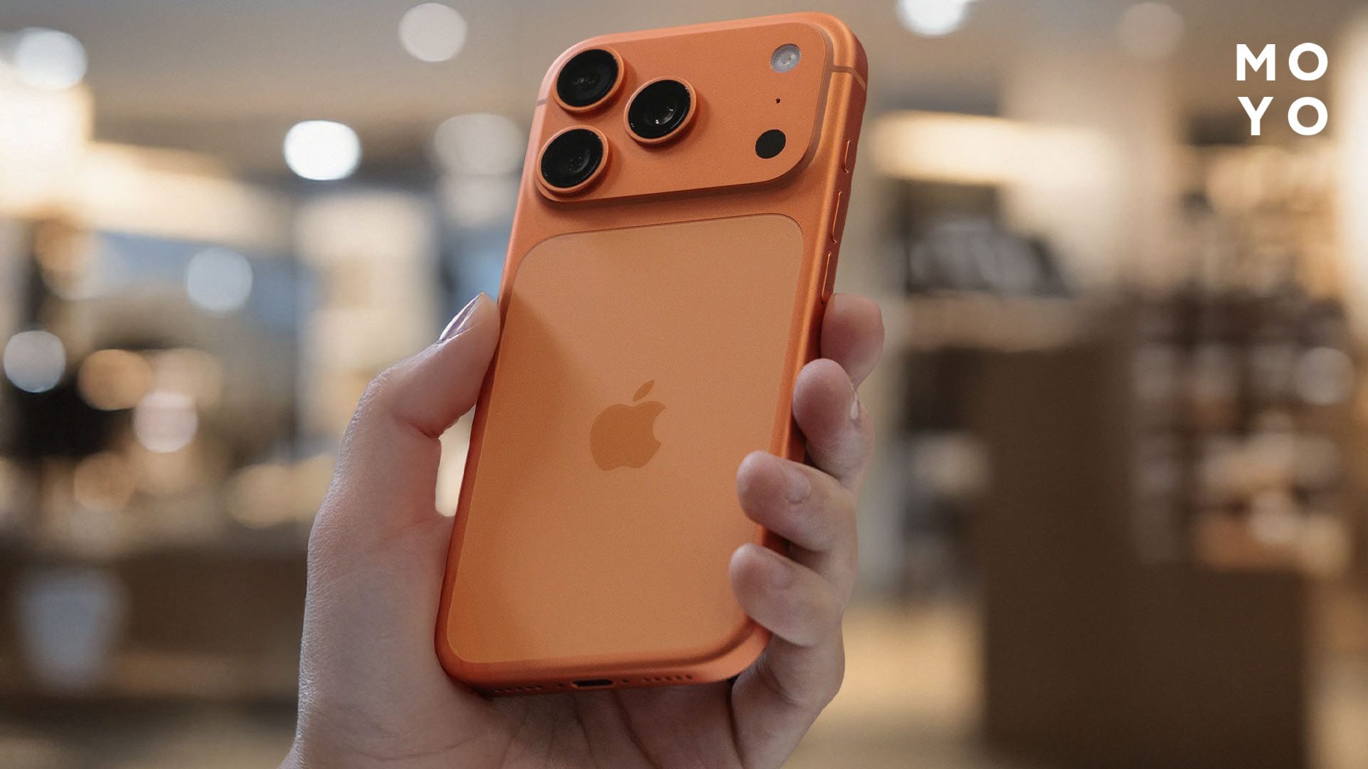 оранжевый iphone 17 pro max в руке у пользователя